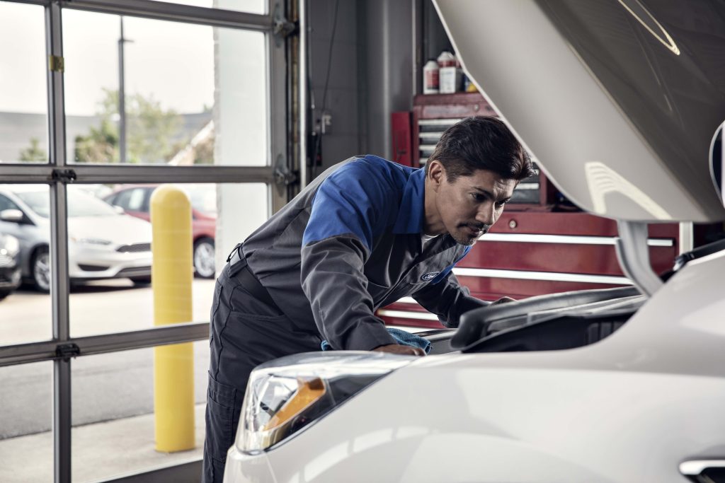 A Ford service technician with their oil change recommendations in New Hudson, MI