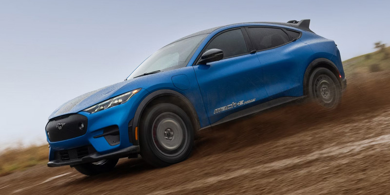 A 2026 Ford Mustang® Mach-E® driving down a muddy hill in New Hudson, MI 