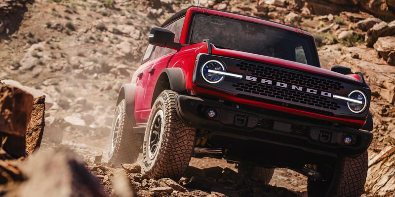 A 2026 Ford Bronco navigating rocky terrain in New Hudson, MI, showcasing its off-road capabilities.