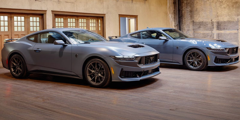 Two Ford Mustangs parked side by side in a garage in New Hudson, MI.