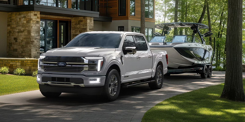 Ford F-150 towing a boat, showcasing its power and capability with Ford Accessories in a scenic outdoor setting.