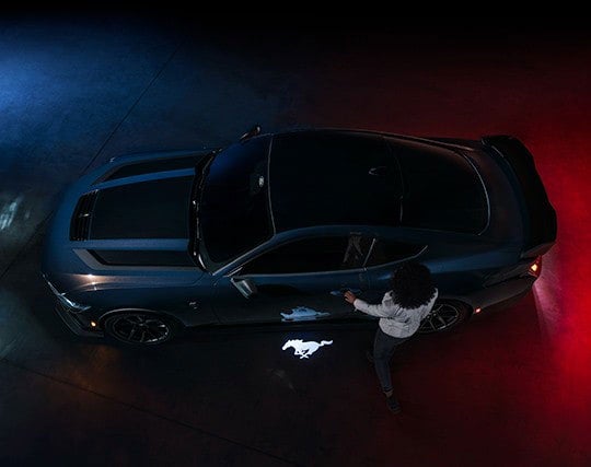 2024 Ford Mustang® Dark Horse™ model with a driver approaching the vehicle | Hines Park Ford in New Hudson MI