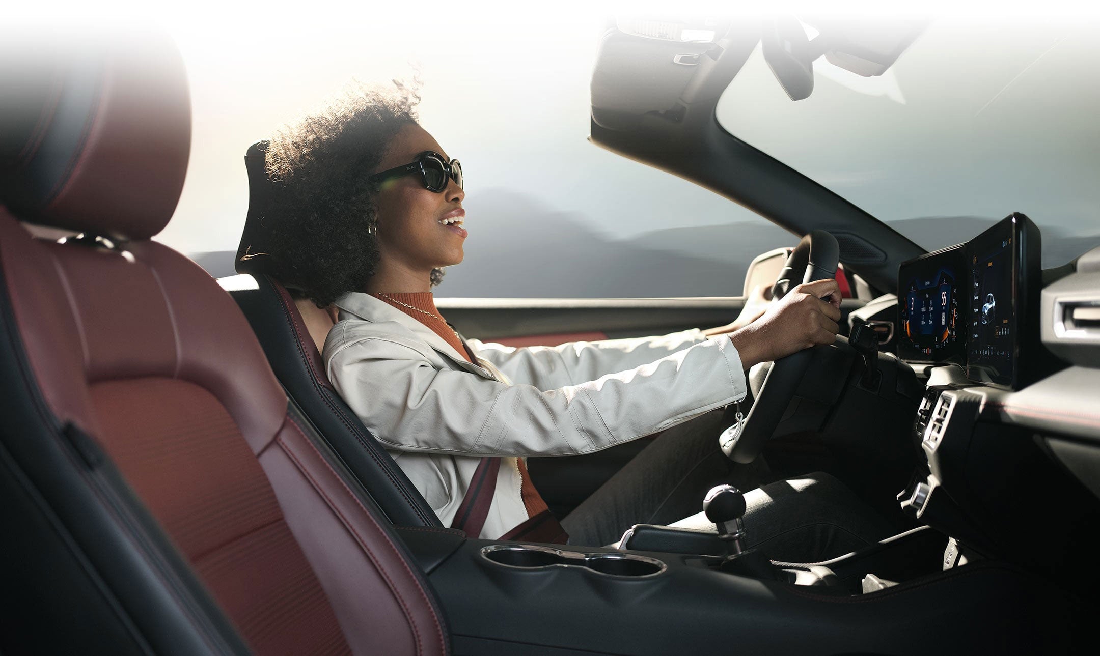 Person sitting in the driver’s seat of a 2024 Ford Mustang® convertible | Hines Park Ford in New Hudson MI