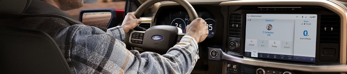 A driver with hands at 10 and 2 on the 2025 Ford F-150 in New Hudson, MI