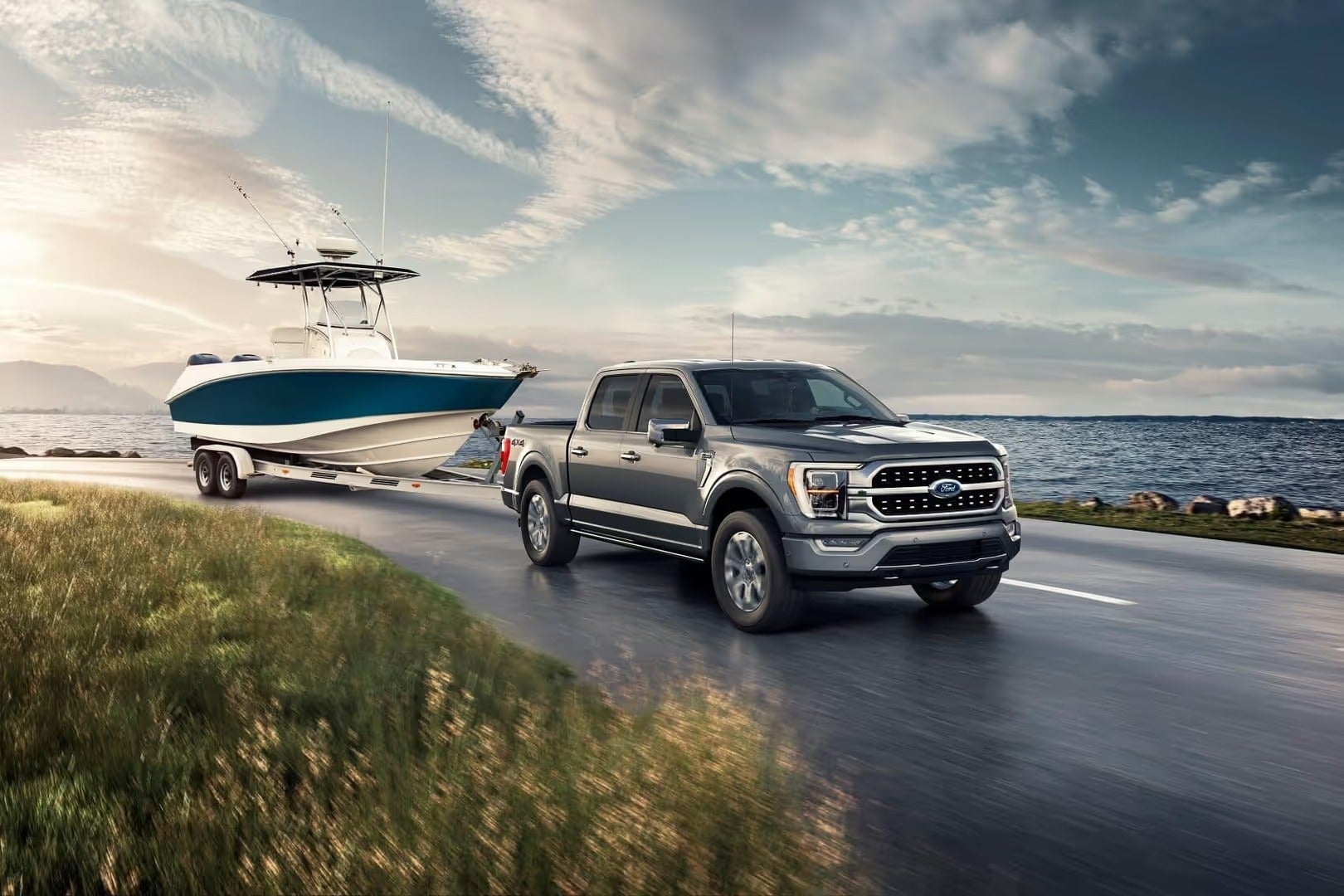 Ford F-150 driving by the water with boat hitched to the back