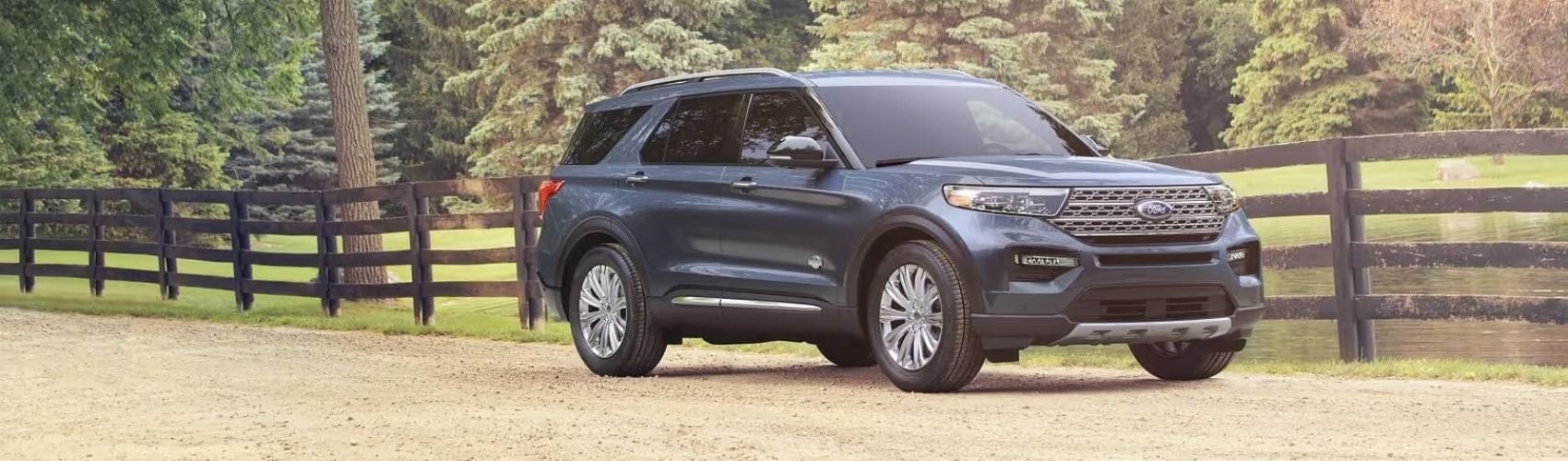 Ford Explorer parked by a fence on a scenic road