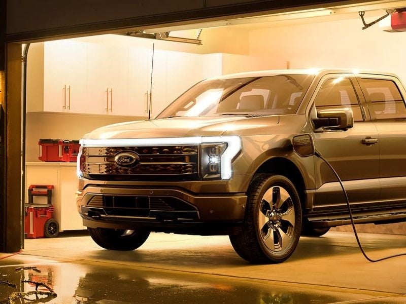 Ford F-150 Lightning parked in a home garage charging using an at-home station