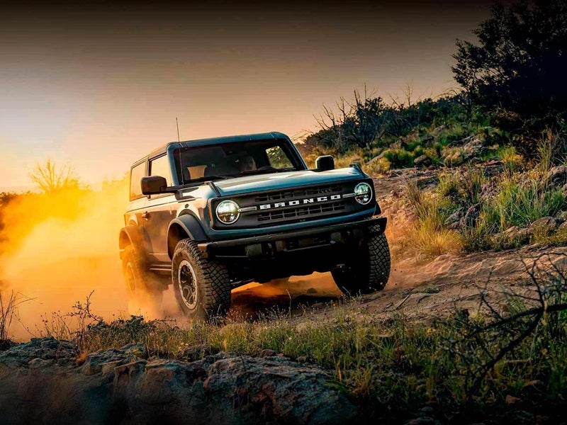 Ford Bronco driving through dirt road