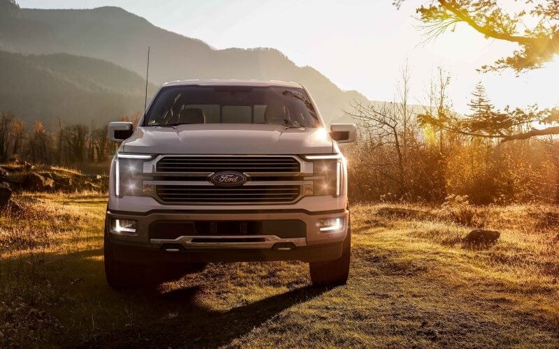 Front of Ford F-150 parked with a mountain and sunset background