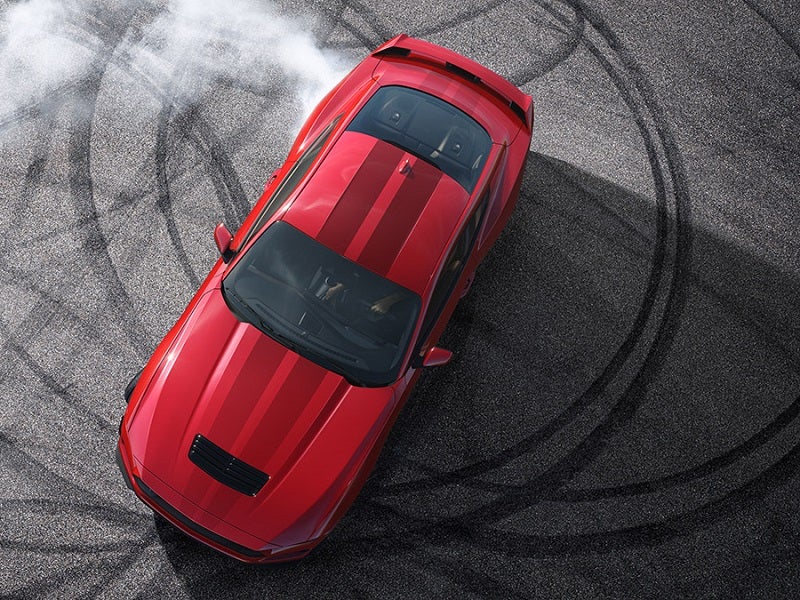 Overhead view of Ford Mustang doing donuts in a parking lot