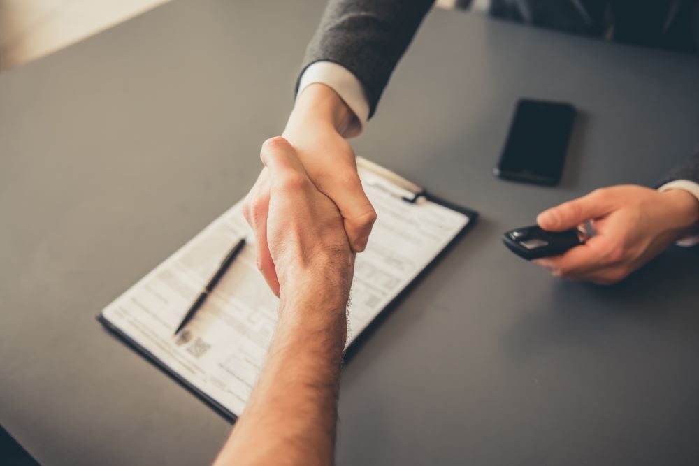 Ford Finance Team member shaking hands with customer after signing financial paperwork