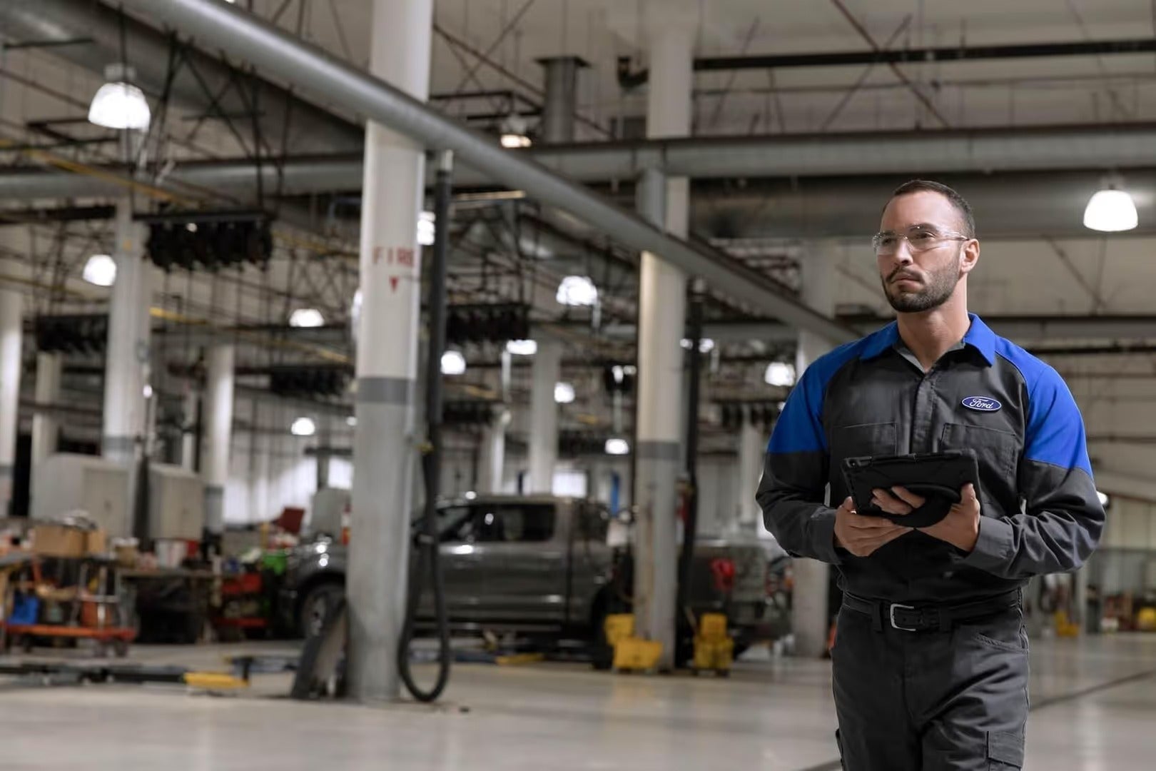 Ford Certified Technician walking to the Ford vehicle in the Service Center